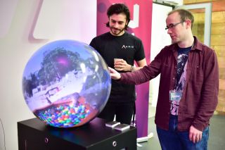 Move Summit 2017 Two people interacting with an video projected onto a sphere.