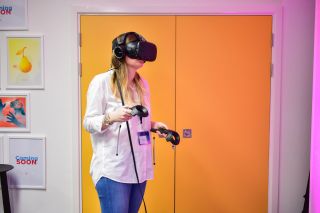 VR at Move Summit 2017 A person wearing a VR headset and holding controllers